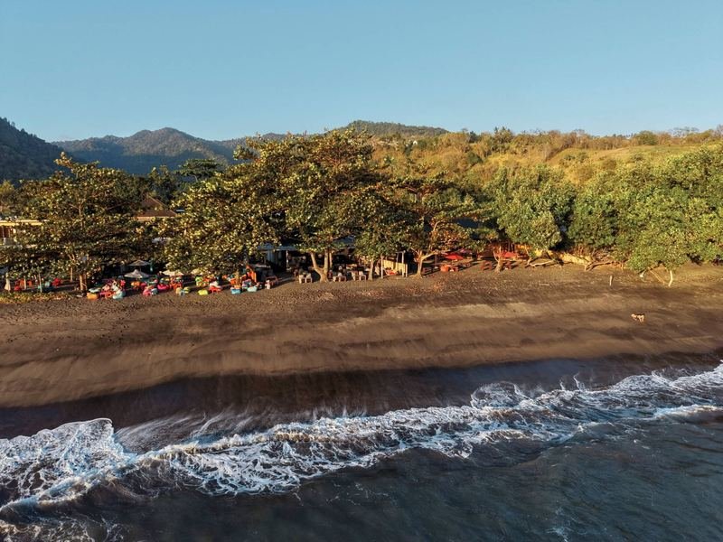 Beachfront bean-bag lounge on the dark-sand beach, from above