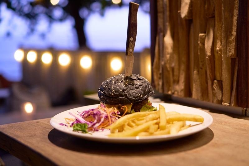 Black-bun burger with fries at dusk