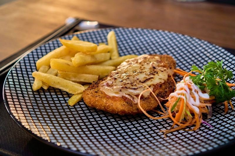 Crumbed cutlet with melted cheese and fries